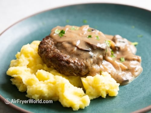 Hamburger steak on mashed potatoes topped with gravy