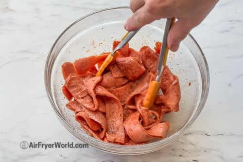 stirring seasoned hot dog strips