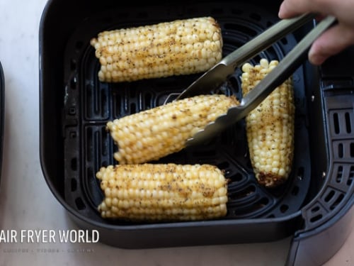 Turning corn in air fryer with tongs