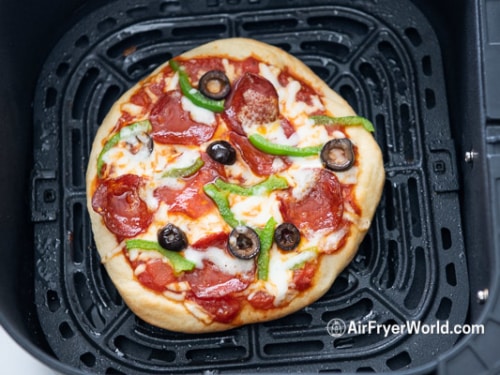Cooked pizza in air fryer basket